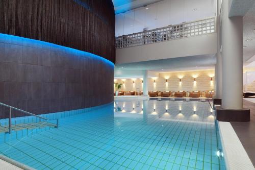 斯图加特梅里迪安斯图加特酒店的一座铺有蓝色瓷砖地板的大型游泳池