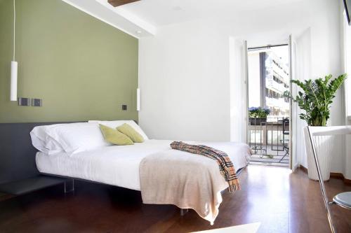 多莫多索拉Ca Bussun的一间卧室配有一张带白色床单和绿色墙壁的床。