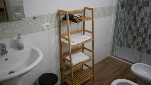 那不勒斯Terminal 1 Guest House的浴室设有水槽旁的木制毛巾架