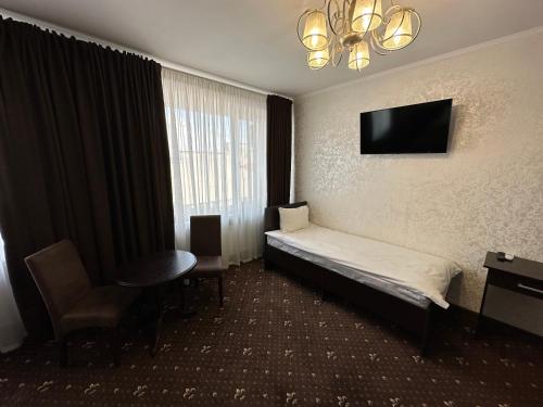 Malyye KhutoraHotel Merry Club的配有一张床和一台平面电视的酒店客房