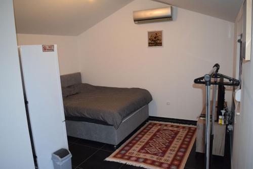 查普利纳Apartman Maga的一间小卧室,配有床和地毯