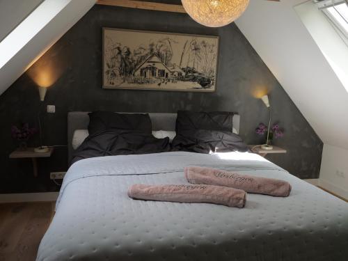 HeerdeLandgoedhoeve Vosbergen的一间卧室配有一张大床和两条毛巾
