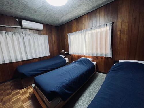 熊本SUMITSUGU HOUSE Grandpa的木镶板客房内的两张床