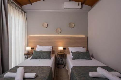 考瑙皮迪亚纳Natura Hill Villa IV Sea View的配有2盏灯的酒店客房的2张床