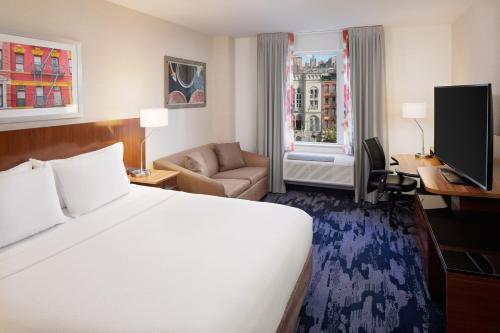 纽约纽约曼哈顿/市中心东费尔菲尔德套房酒店的酒店客房设有一张大床和一张沙发。