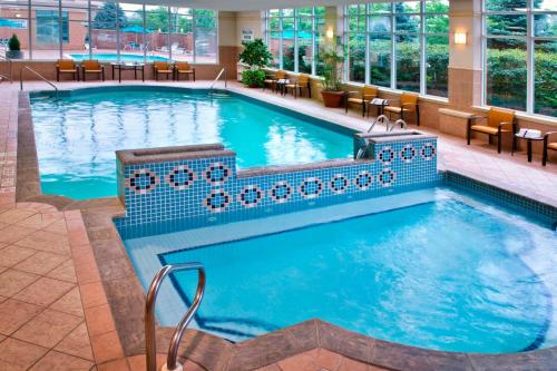 尼亚加拉瀑布尼亚加拉瀑布万怡酒店 的酒店的大型游泳池配有桌椅
