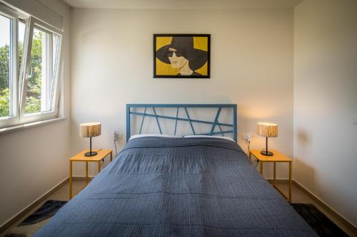 法扎纳Villa Skrila的一间卧室配有一张带两盏灯的蓝色床。