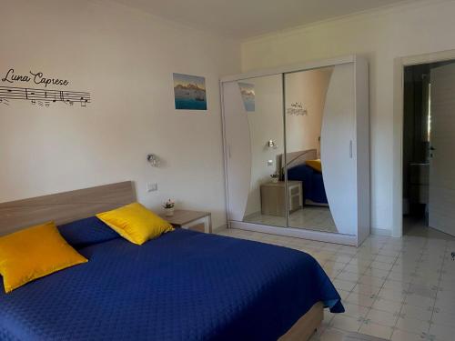 阿纳卡普里Capri Melody的一间卧室配有蓝色和黄色的床和镜子
