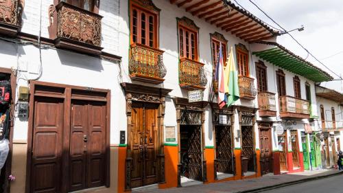 SalaminaHospedaje Casa Real的有一排带有木门和窗户的建筑