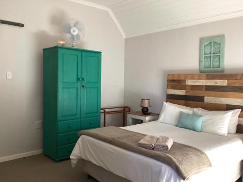 伯格维尔Ledges Retreat的一间卧室配有绿色橱柜和一张床