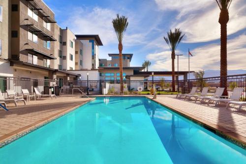 拉昆塔Residence Inn by Marriott La Quinta的一座棕榈树游泳池和一座建筑
