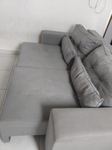 大坎皮纳Apartamento temporada para São joao的客房内的一张带两个枕头的灰色沙发