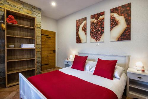 马来济格TouristFarm - apartments "RED FAIRYTALE"的一间卧室配有一张带红色枕头的大床
