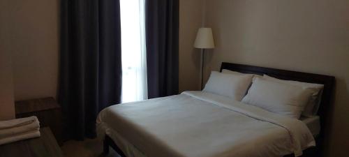 马尼拉81 Newport,NAIA 3,Pasay Condotel的一间卧室配有一张带白色床单的床和一扇窗户。