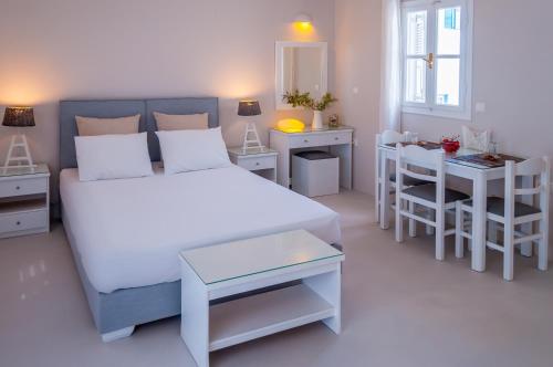 阿达玛斯米洛斯湾套房酒店的一间卧室配有一张床、一张桌子和一张书桌