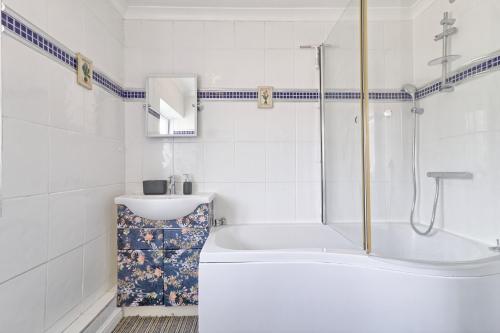 巴塞尔顿Elegant 3 Bedroom House in Basildon - Essex Free Parking & Superfast Wifi, upto 6 Guests的白色的浴室设有浴缸和水槽。