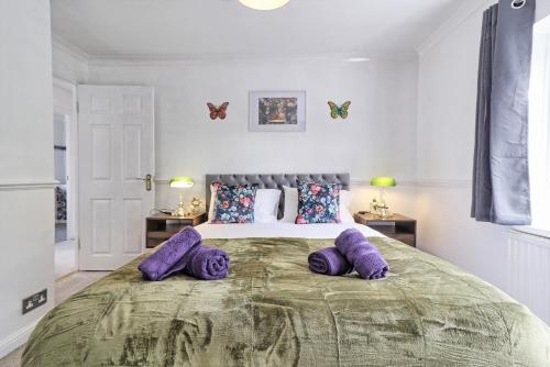 巴塞尔顿Elegant 3 Bedroom House in Basildon - Essex Free Parking & Superfast Wifi, upto 6 Guests的一间卧室配有一张带紫色枕头的大床