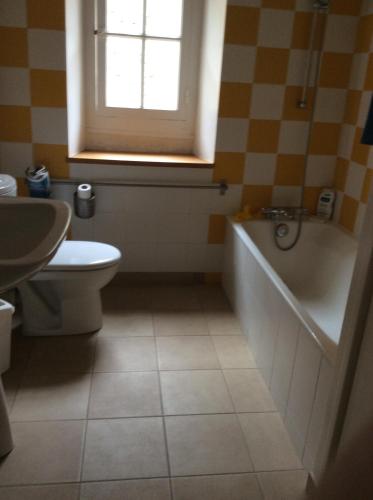 Chambres d'hôtes au calme的带浴缸、卫生间和窗户的浴室