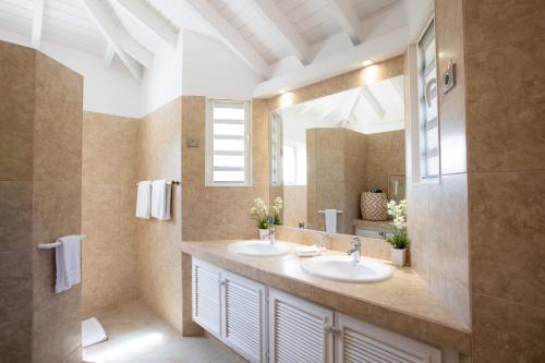 泰尔斯贝斯Villa Madras的一间带两个盥洗盆和大镜子的浴室