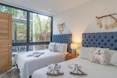 图卢姆Exclusive Villa "Town House" Luxury Amenities in Tulum的一间卧室设有两张床和大窗户