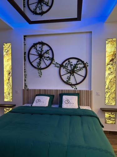 格勒诺布尔Grenoble LA SUITE 2 spa jaccuzzi et sauna privatif的卧室配有两把钟,墙上挂着一张床铺