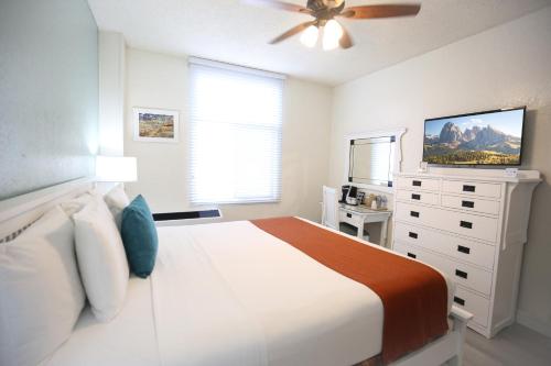 洛杉矶Hotel Carmel Santa Monica的白色卧室配有床和吊扇