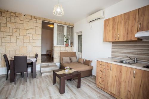 乌尔齐尼Apartments Jelena Ulcinj的厨房以及带沙发和桌子的客厅。