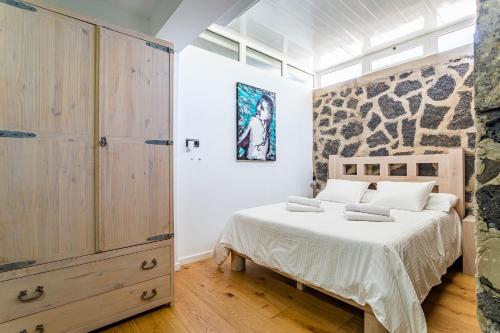 普拉亚布兰卡Villa Olive Tree的一间卧室设有一张床和石墙