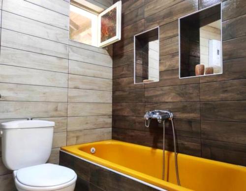 奥赫里德Villa Forest Paradise的一间带黄色浴缸和卫生间的浴室