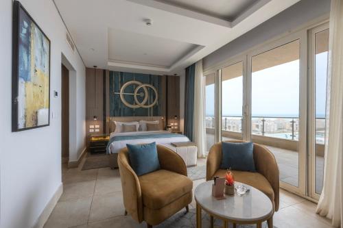 阿莱曼Tolip Resort Sunrays New- Alamein的酒店客房带一张床、一张桌子和椅子