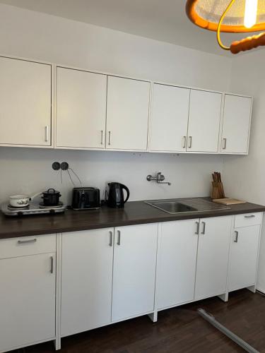 多克西Penzion U Radnice的厨房配有白色橱柜和水槽