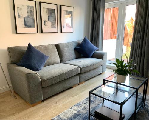 爱丁堡3 bedroom - 2 bathroom Townhouse in Corstorphine Near Murrayfield Stadium - Direct Bus To Edinburgh City Centre in 20 Minutes - Two Private Parking Spaces - Private Sunny Garden - Recently Refurbished的客厅配有沙发和桌子