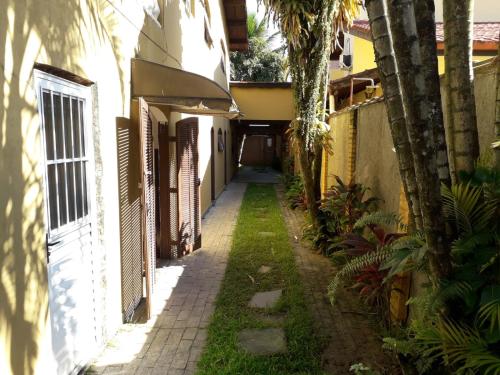 伯迪亚哥Hostel Canto de Bertioga的棕榈树的小巷和建筑