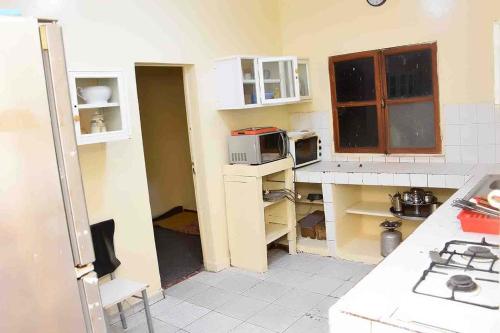 努瓦克肖特Jolie Maison的厨房配有白色橱柜和微波炉