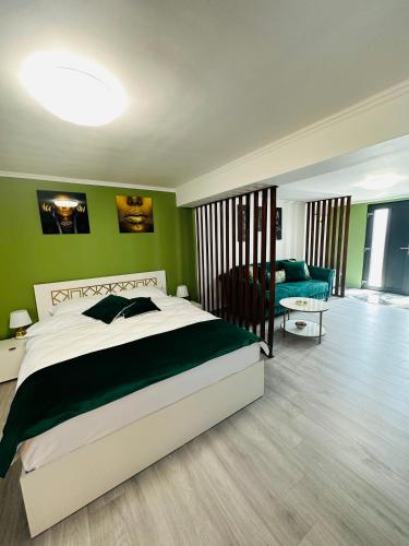 锡比乌Luxor Apartament Sibiu的一间卧室设有一张大床和绿色的墙壁