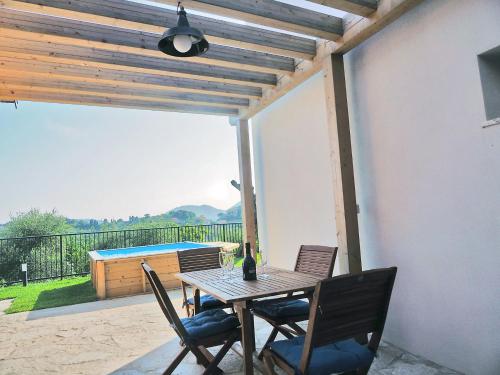 莱里奇La Valle Incantata的庭院里配有桌椅和一瓶葡萄酒