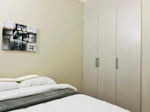 哈博罗内Brilliant Home的一间卧室配有一张床和一个橱柜