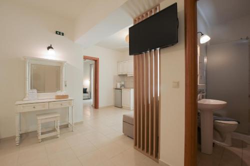卡拉马基Philharmonie Hotel的浴室设有水槽,墙上配有电视