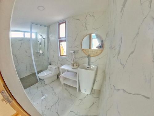 那空拍侬府The3 Happiness Nordic Private Home的白色大理石浴室配有水槽和镜子