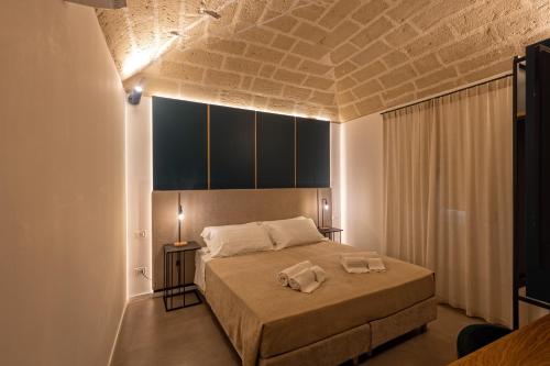 法维尼亚纳Mazzini Accommodation的一间卧室配有一张床,上面有两条毛巾