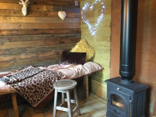 特罗布里奇Dolly’s shepherds hut的客房设有燃木火炉和带炉灶的长凳。