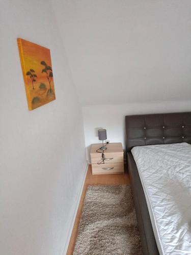 波鸿Nette Kuschelige Wohnung的卧室配有一张床,墙上挂有绘画作品