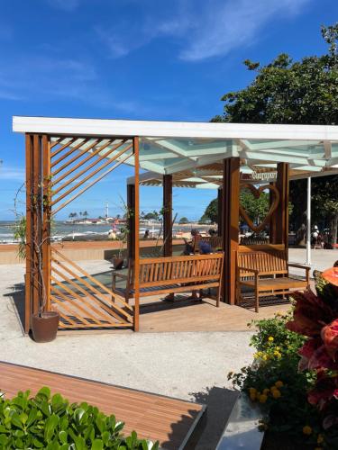 瓜拉派瑞Hope Hostel Guarapari的海滩上带2个长椅的凉亭