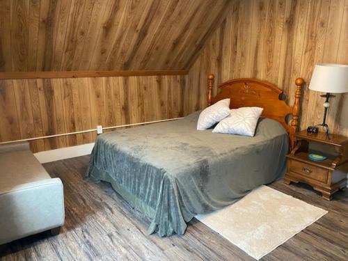 BarreFabulous Barre Apts!的卧室配有一张床铺,位于带木墙的房间内