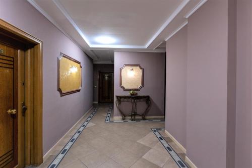 地拉那王子酒店的走廊设有紫色墙壁、桌子和镜子