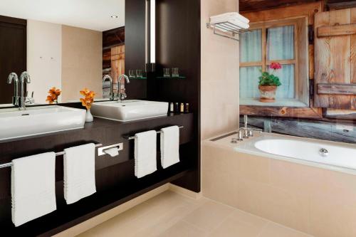 弗赖辛万豪酒店慕尼黑机场店的浴室配有2个盥洗盆和1个浴缸。