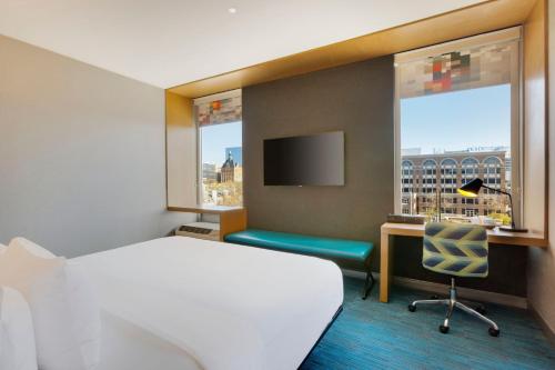 密尔沃基雅乐轩酒店，密尔沃基市中心的配有一张床、一张书桌和一扇窗户的酒店客房