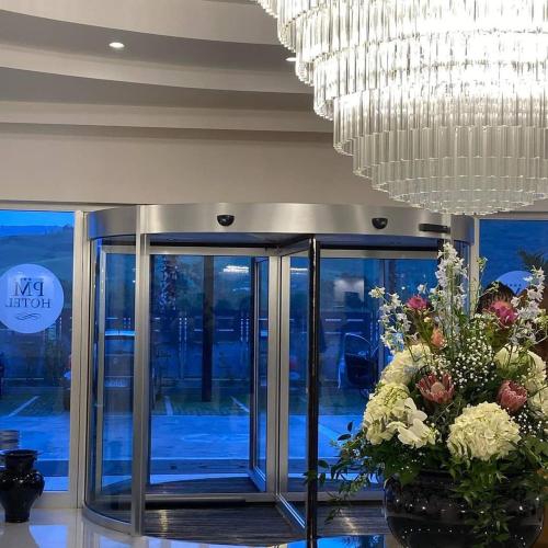 卡坦扎罗丽都PM Hotel的大堂设有大吊灯和鲜花