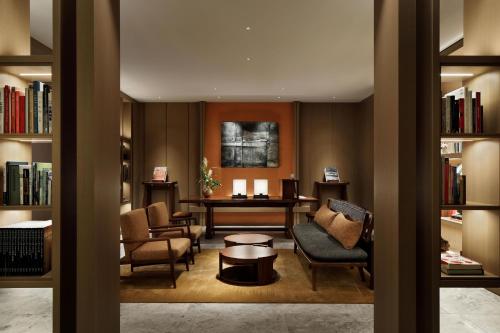 京都HOTEL THE MITSUI KYOTO, a Luxury Collection Hotel & Spa的图书馆配有椅子、桌子和书籍