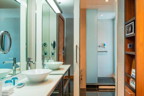 阿布扎比阿布扎比雅乐轩酒店的一间带两个盥洗盆和淋浴的浴室